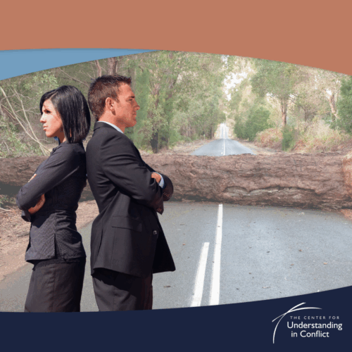 An image of a man and woman back to back with a log in the road behind them.